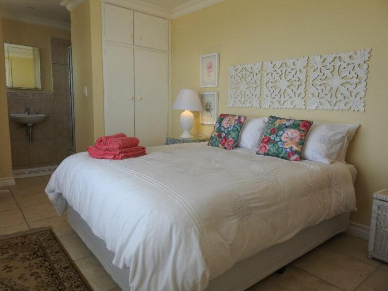 Room 1 with queen bed and door to the en-suite bathroom