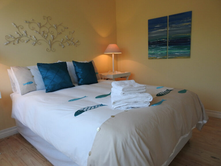 Room 3 double bed with tree wall art and bedside lamp
