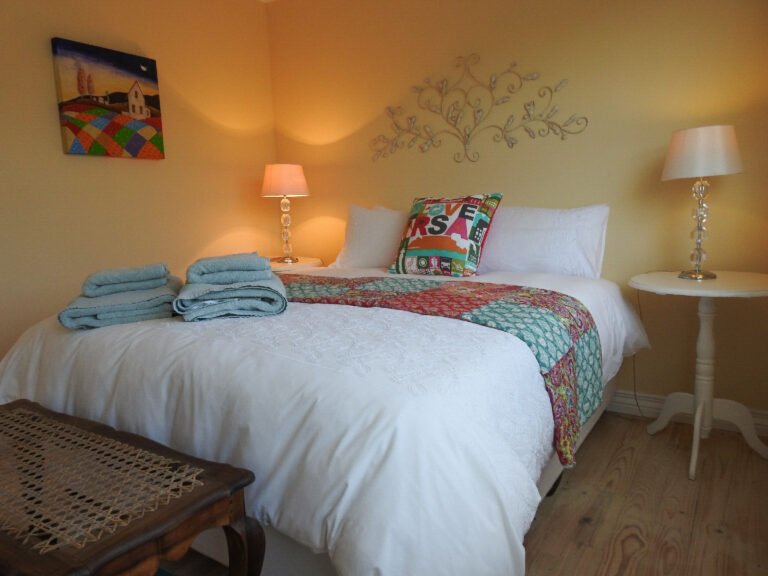 Room 4 queen bed with a colourful quilt