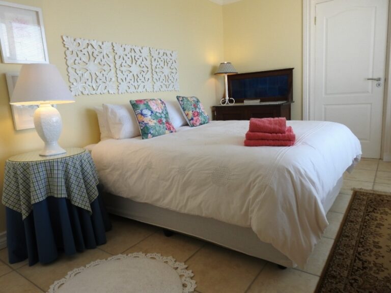 Room 1 at Julsie's Home: queen bed with white linen and a carved white wall panel