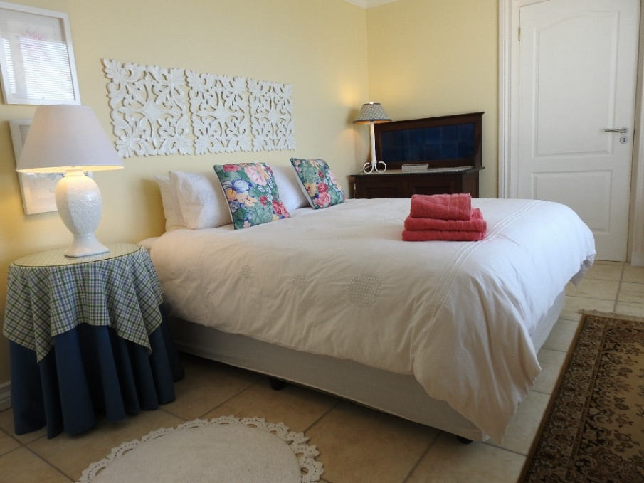 Room 1 at Julsie's Home: queen bed with white linen and a carved white wall panel