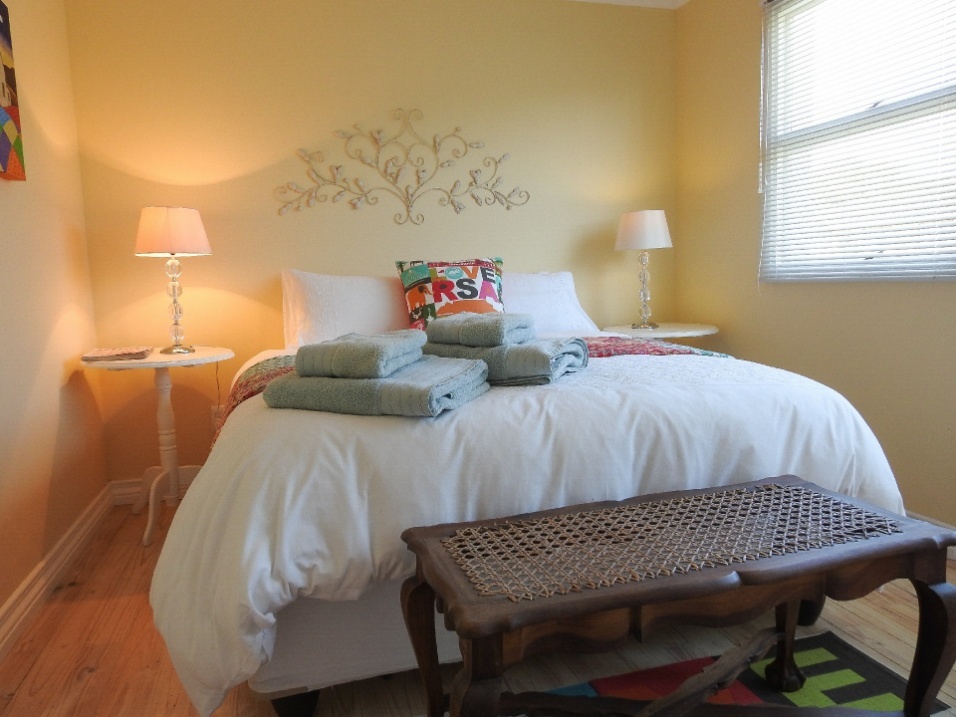 Room 4 at Julsie's Home: queen bed with a woven bench at its foot